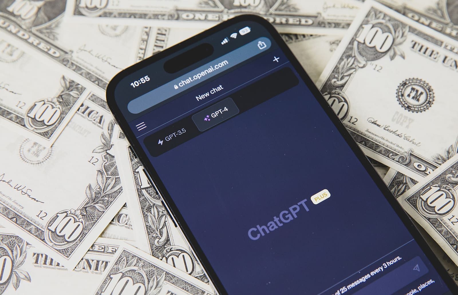 Pametni telefon s otvorenim ChatGPT-om na američkim novčanicama
