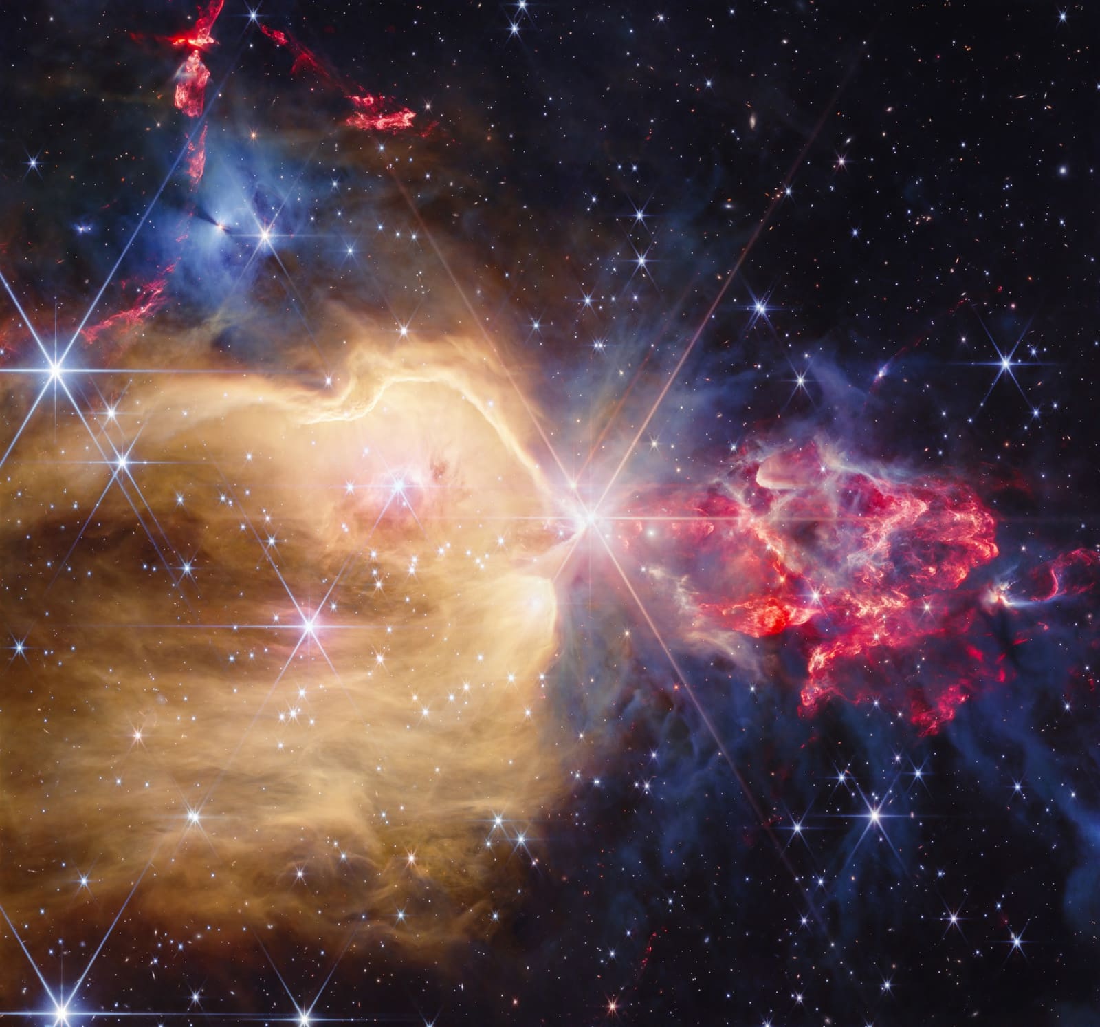 Webbova snimka NGC 7129 kamerom NIRCam, sa zlatnim oblacima vodika i crvenim mlazovima